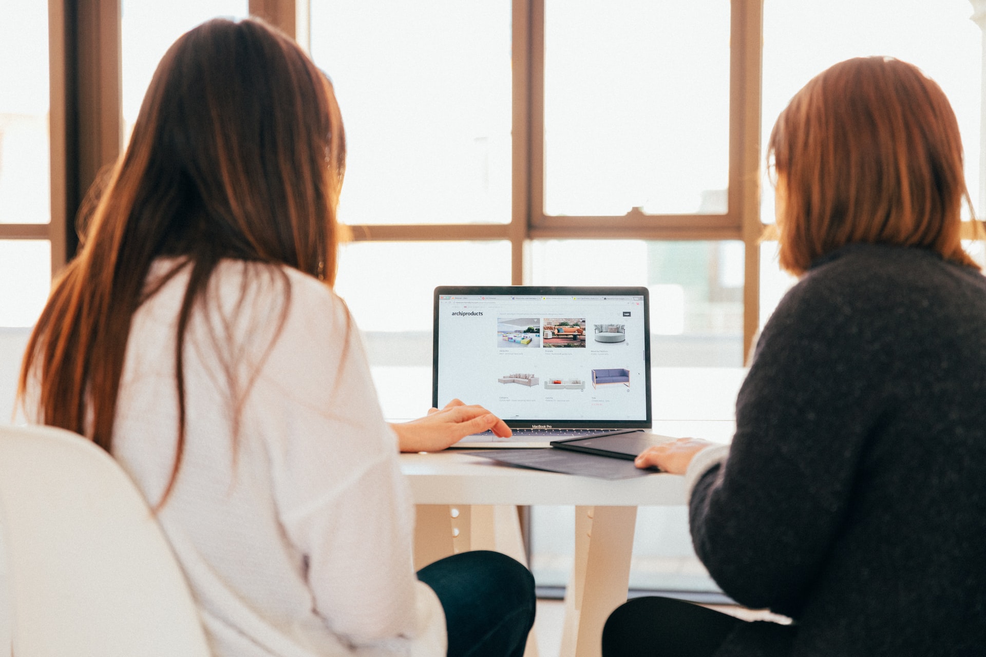 Two women viewing website on laptop